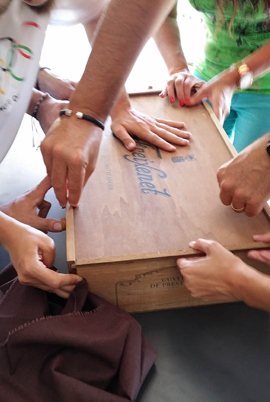 several people working together trying to open a box